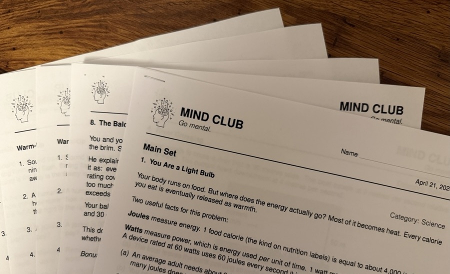 Mind Club problem sheets fanned out on a table