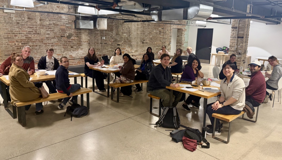 Mind Club session — participants seated around tables doing pen and paper exercises