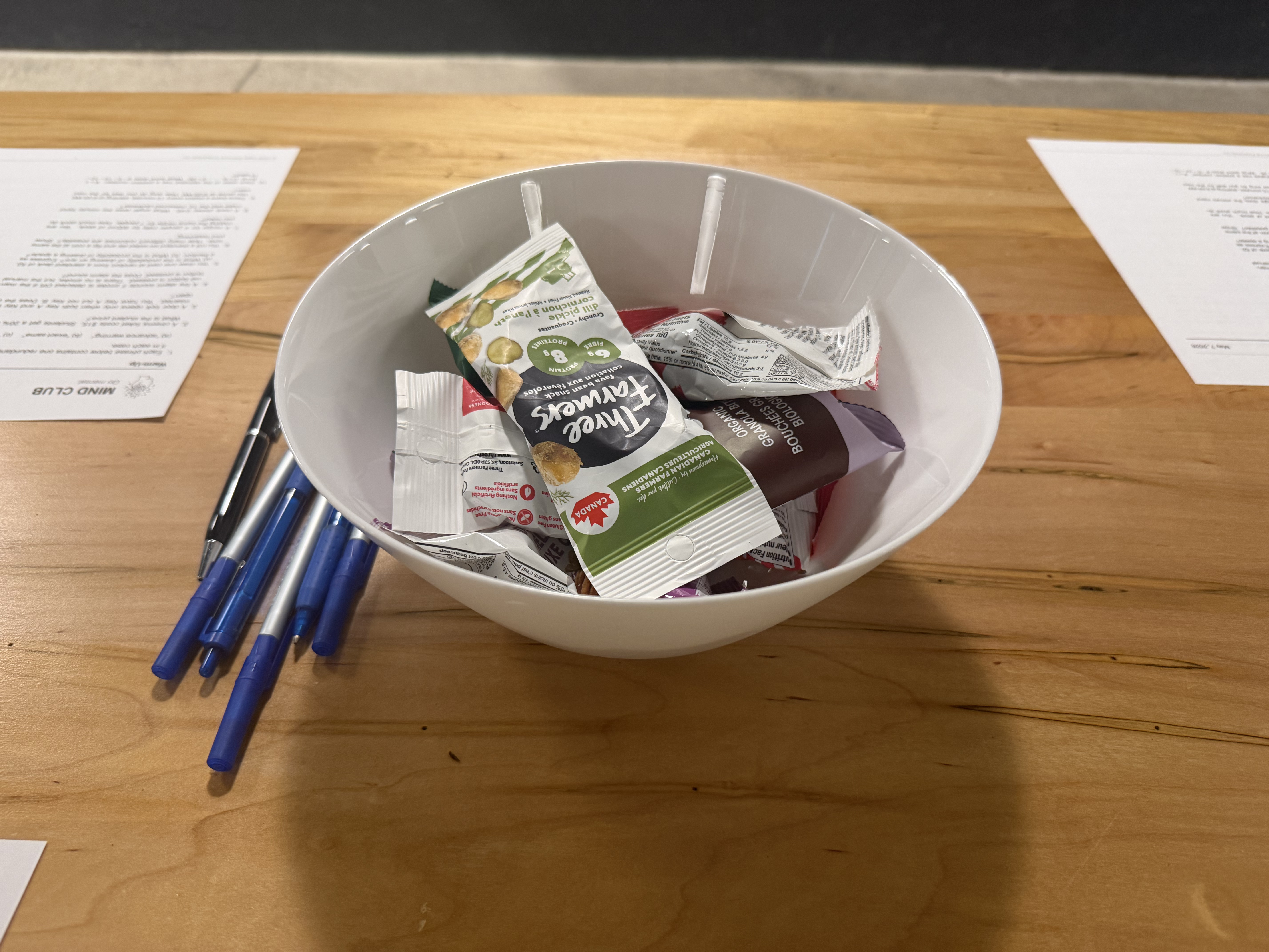 Bowl of snacks and pens on a table